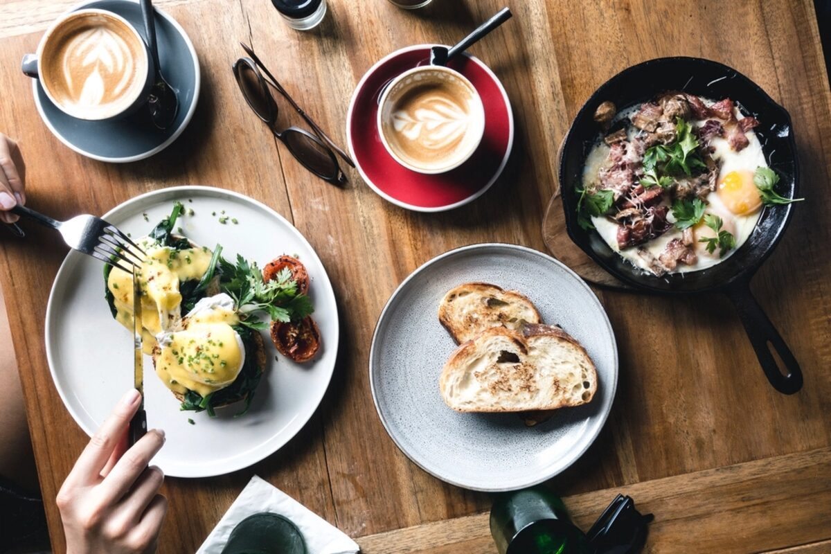 A warm brunch table with plates, coffee, and toast