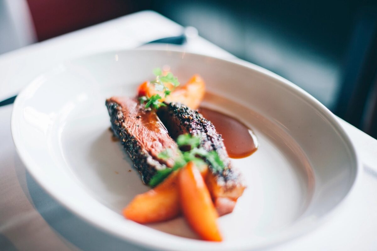 Glazed salmon with roasted carrots on a white plate