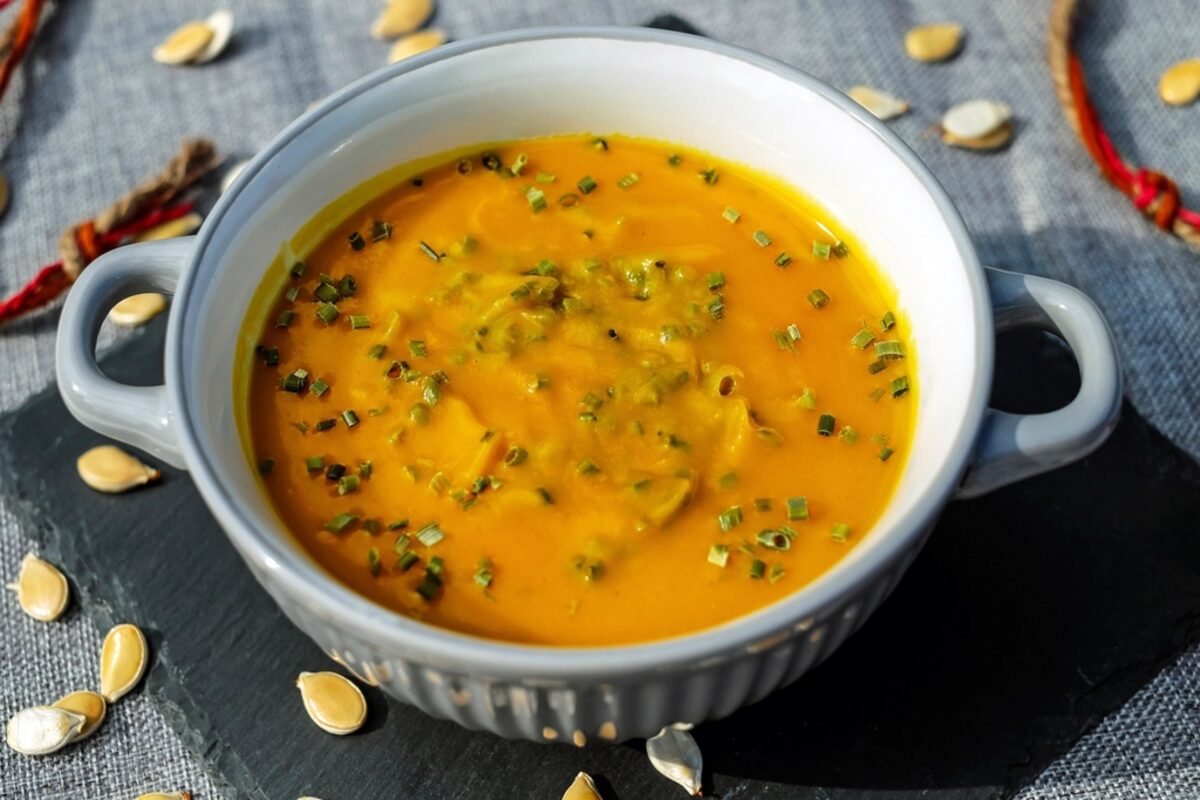 A bowl of pumpkin soup garnished with herbs
